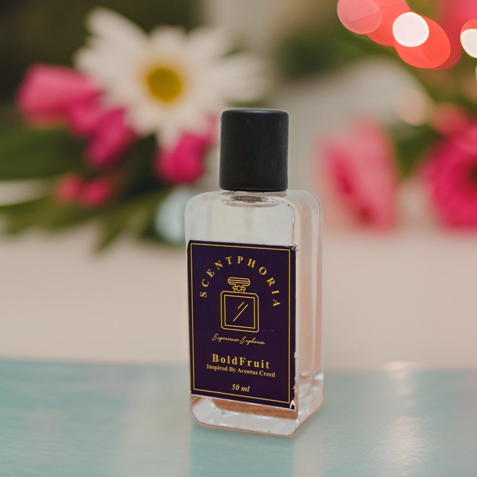 Scentphoria Bold Fruit perfume bottle on a table with flowers in the background