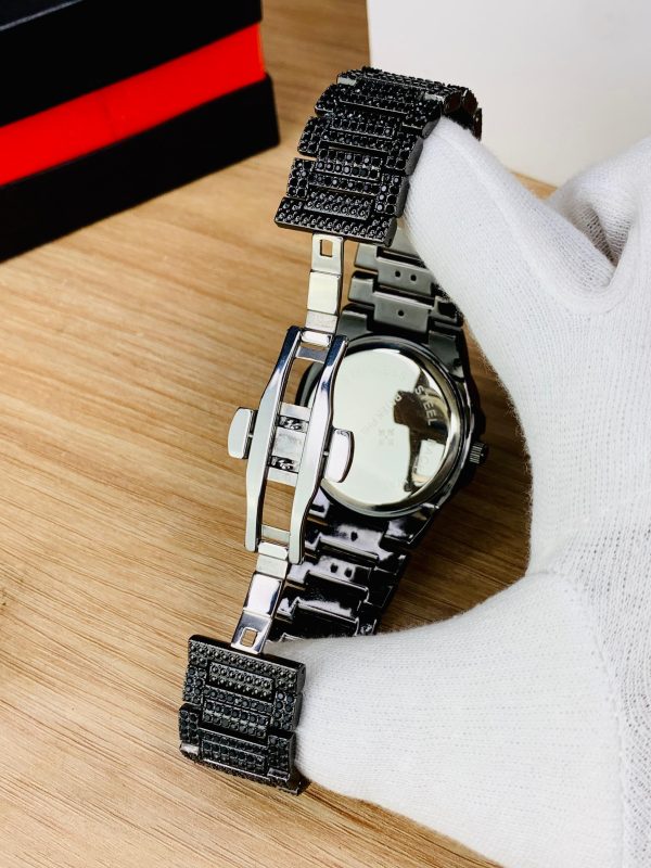 Luxury watch with black and silver design on a wooden surface