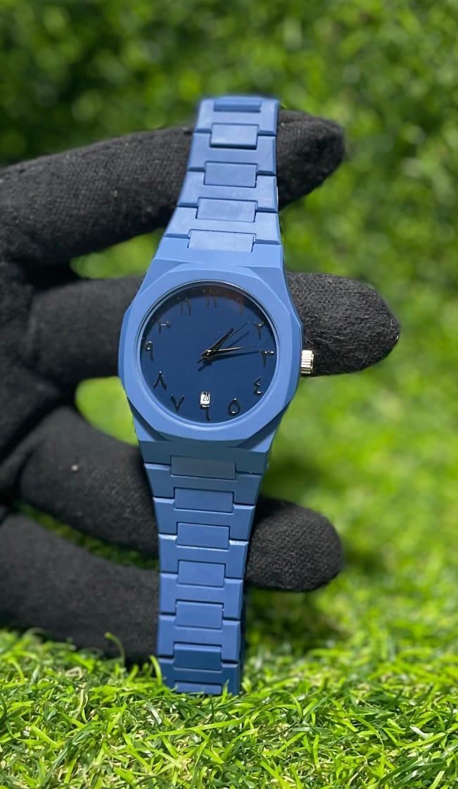 Blue watch held by a gloved hand against a grassy background
