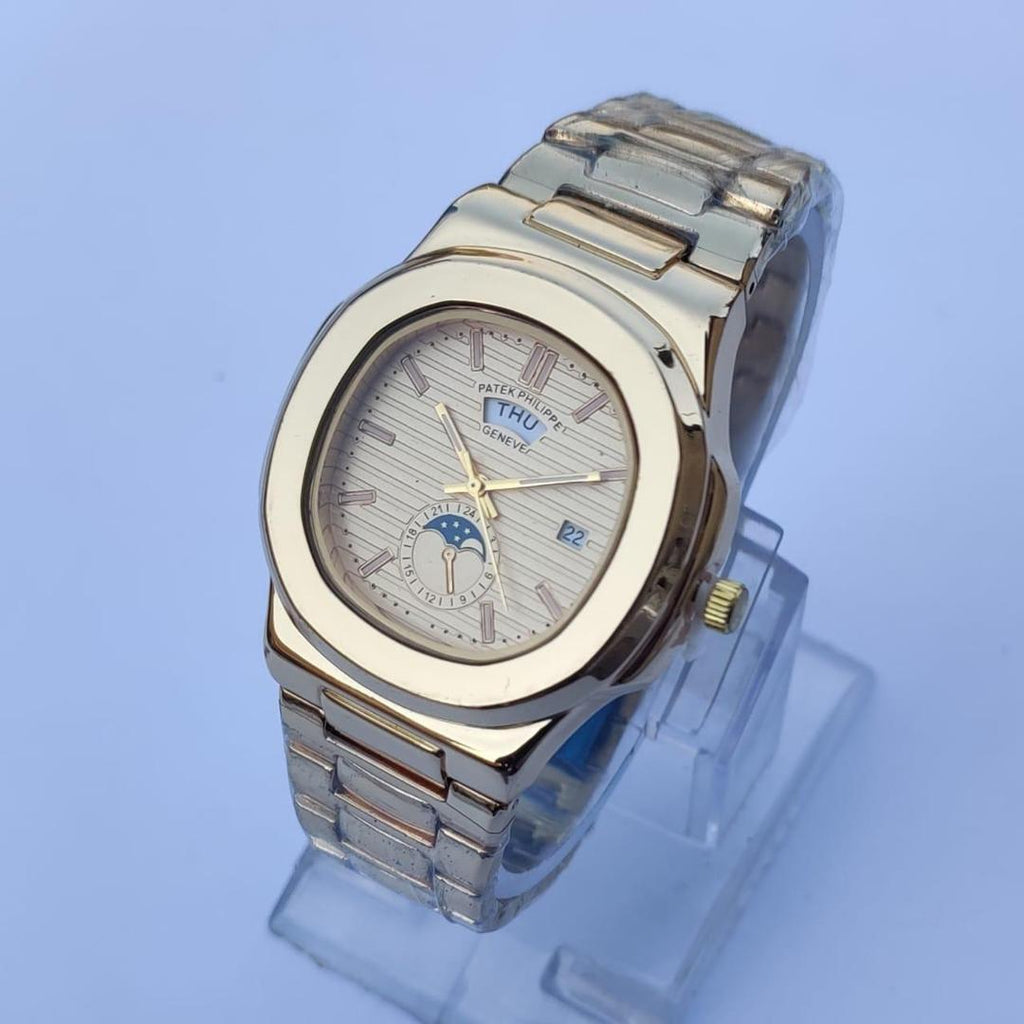 Silver and gold watch on a clear stand with a light blue background